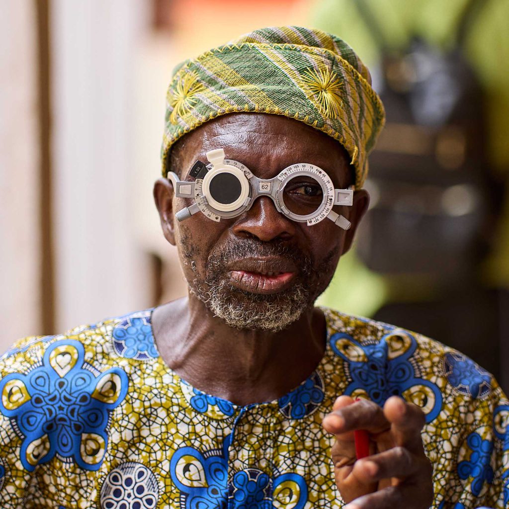 An elderly man smiles during a vision screening